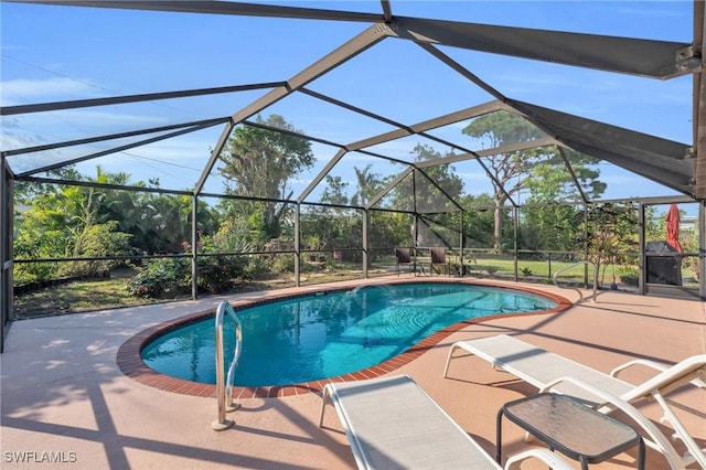 view of pool with glass enclosure and a patio area