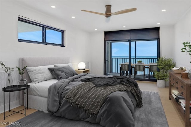 bedroom with ceiling fan and a water view