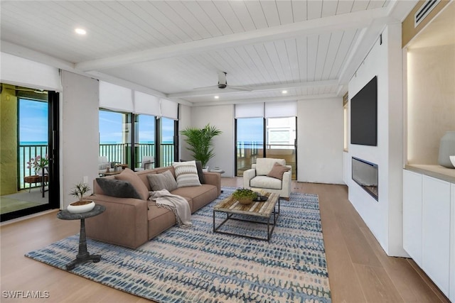 living room with wood ceiling, a water view, beamed ceiling, ceiling fan, and hardwood / wood-style flooring