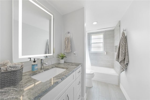 full bathroom with hardwood / wood-style flooring, shower / bath combo with shower curtain, vanity, and toilet