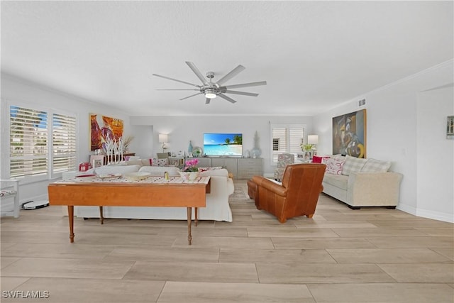 living room with ceiling fan, ornamental molding, and a wealth of natural light