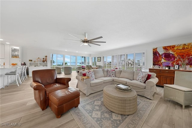 living room with light wood-type flooring and ceiling fan