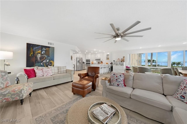 living room with light hardwood / wood-style flooring and ceiling fan