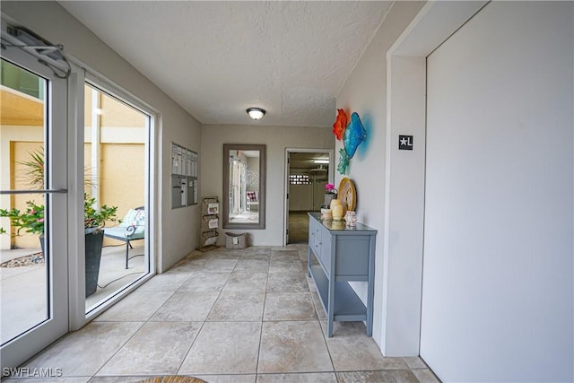 mudroom featuring light tile patterned flooring and a textured ceiling