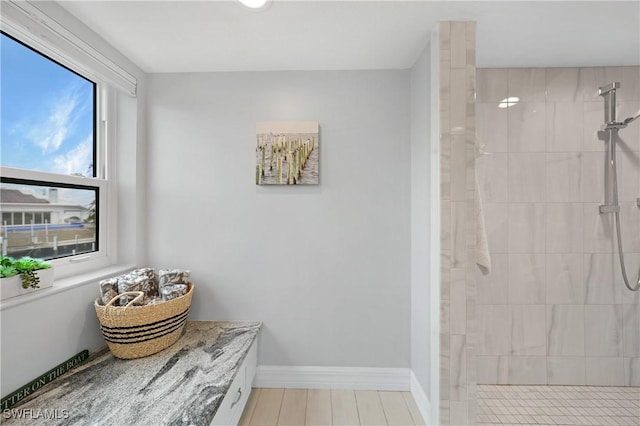 bathroom with hardwood / wood-style flooring and tiled shower