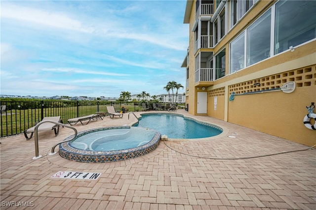 view of swimming pool with a patio and a hot tub