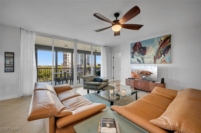 living room featuring ceiling fan, light tile patterned floors, and a wall of windows