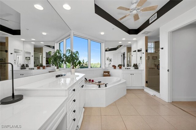 bathroom with ceiling fan, tile patterned floors, shower with separate bathtub, a tray ceiling, and vanity