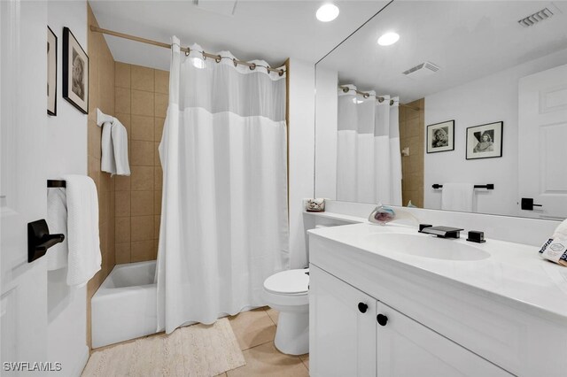 full bathroom with shower / bath combo with shower curtain, tile patterned flooring, vanity, and toilet