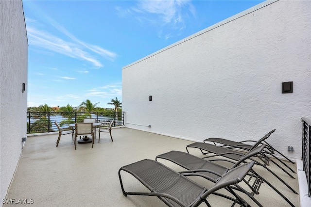 view of patio featuring a balcony and a water view