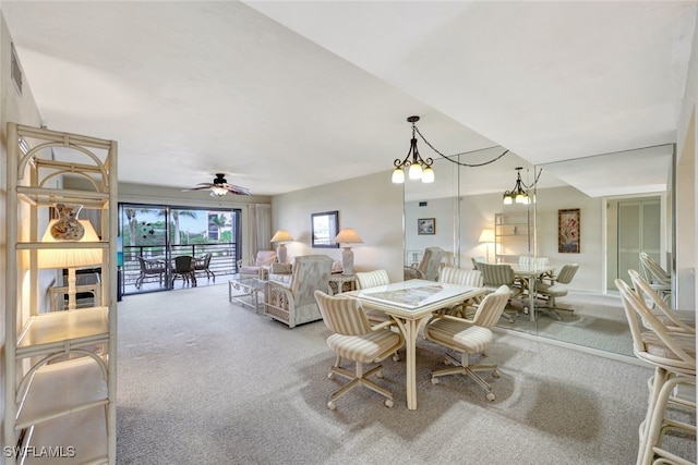 carpeted dining room with ceiling fan with notable chandelier