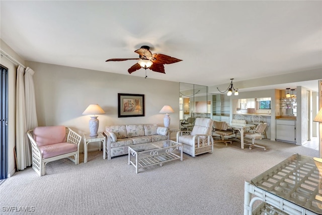 carpeted living room with ceiling fan with notable chandelier