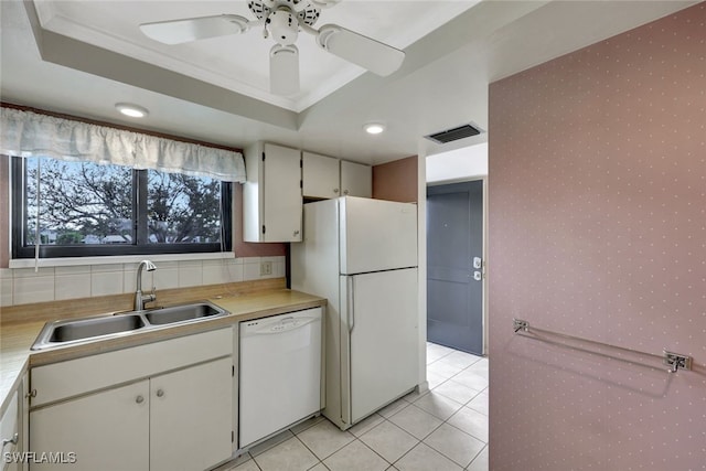 kitchen with sink, ornamental molding, white appliances, and a raised ceiling