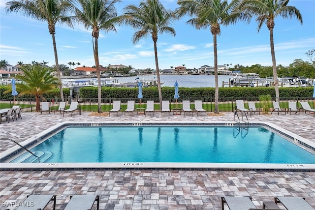 view of swimming pool with a patio area and a water view