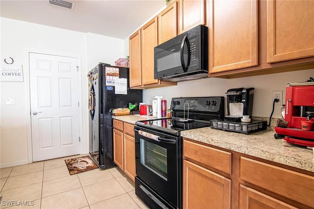 kitchen with light tile patterned flooring and black appliances