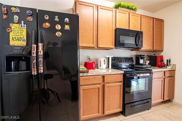 kitchen with light tile patterned flooring and black appliances