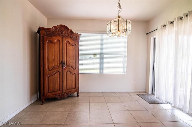 dining space with a notable chandelier and light tile patterned floors