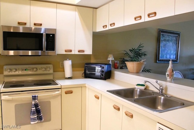 kitchen featuring sink, white cabinets, and white appliances