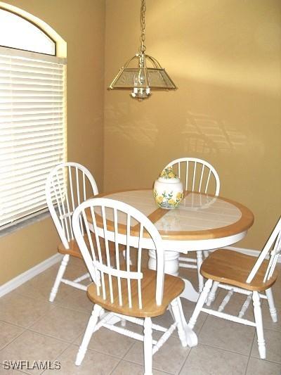 tiled dining space with a notable chandelier