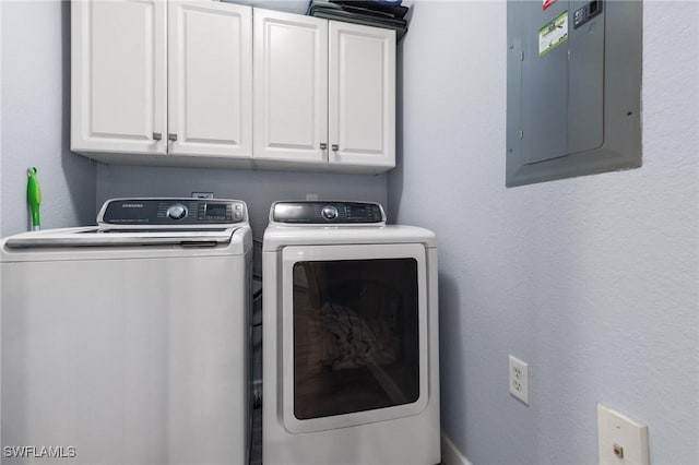 washroom with electric panel, cabinets, and washer and dryer