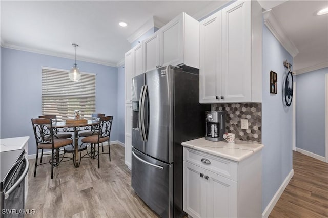 kitchen featuring backsplash, crown molding, stainless steel refrigerator with ice dispenser, hanging light fixtures, and white cabinetry