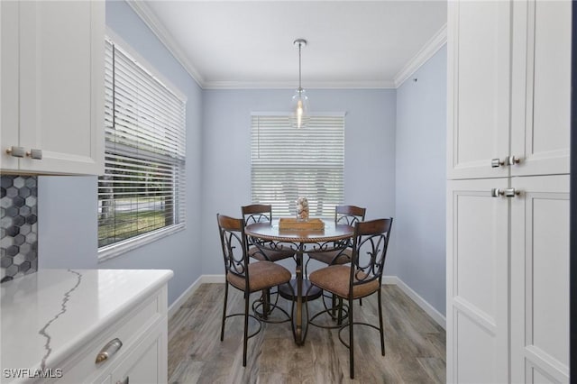 dining room with light hardwood / wood-style floors and ornamental molding