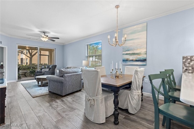 dining area featuring wood-type flooring, ceiling fan with notable chandelier, plenty of natural light, and ornamental molding