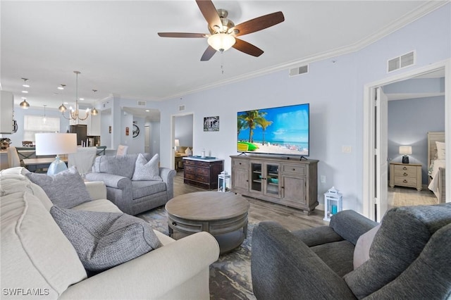 living room with light hardwood / wood-style flooring, ceiling fan with notable chandelier, and ornamental molding