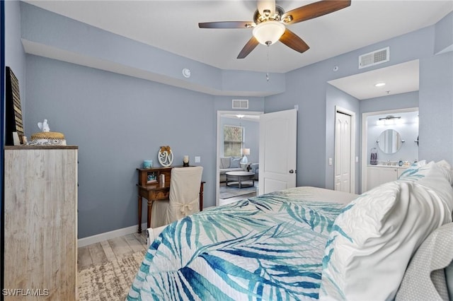 bedroom with ceiling fan, a closet, light hardwood / wood-style floors, and ensuite bath