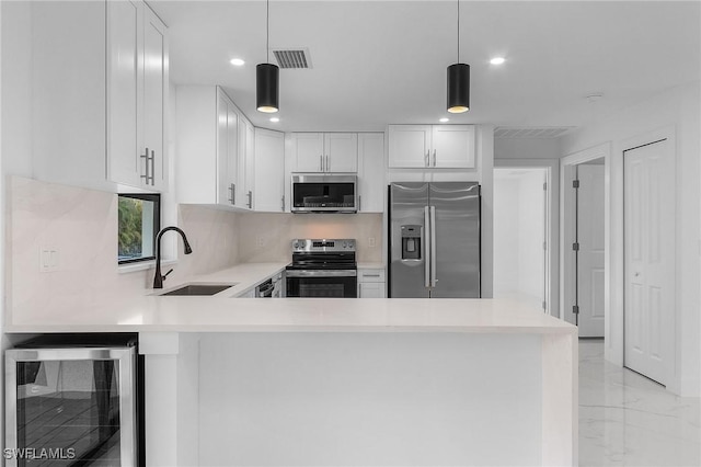 kitchen with stainless steel appliances, white cabinetry, sink, and wine cooler