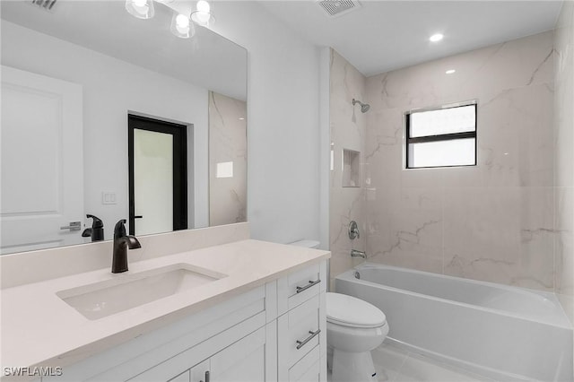 full bathroom featuring toilet, vanity, and tiled shower / bath