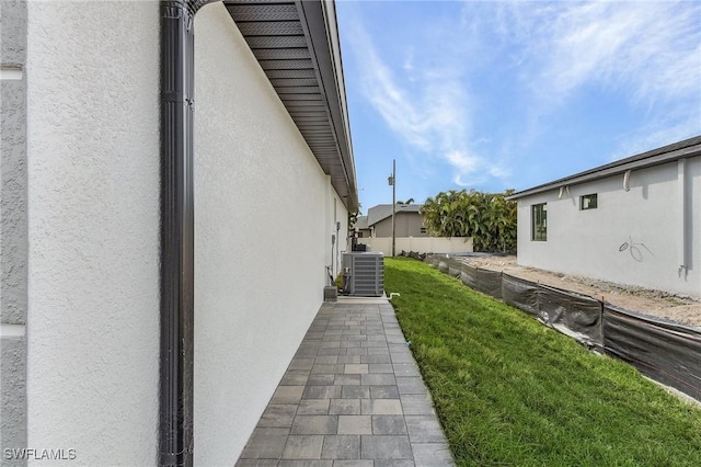 view of home's exterior with central air condition unit and a lawn