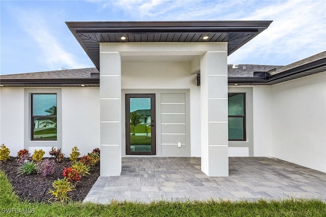 view of exterior entry featuring a patio area