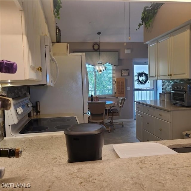 kitchen with range with electric cooktop, hanging light fixtures, and a notable chandelier