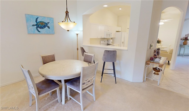 tiled dining area featuring ceiling fan