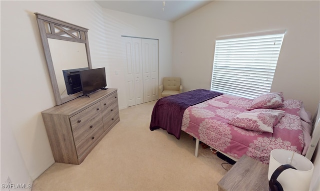 bedroom featuring light colored carpet and a closet