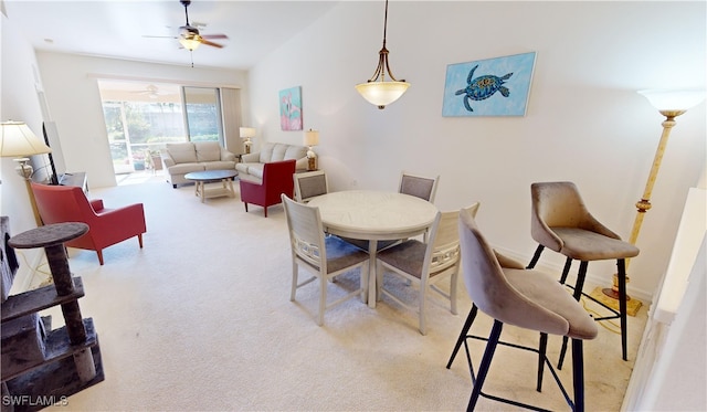 carpeted dining room featuring ceiling fan