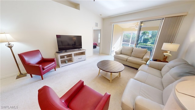 living room featuring ceiling fan, light colored carpet, and lofted ceiling