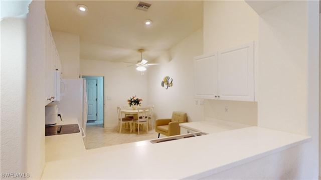 kitchen featuring ceiling fan, sink, light tile patterned floors, white cabinets, and range