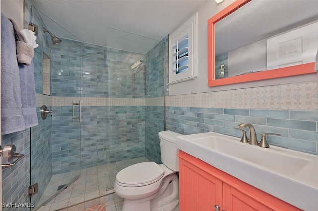 bathroom with an enclosed shower, tile patterned floors, tile walls, toilet, and vanity