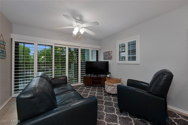 living room featuring ceiling fan and dark hardwood / wood-style flooring