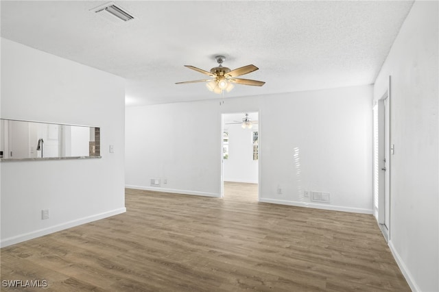 spare room with sink, a textured ceiling, hardwood / wood-style floors, and ceiling fan