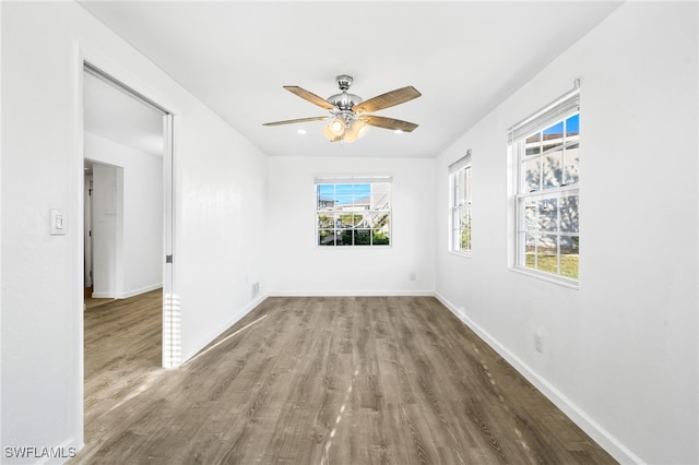 unfurnished room with a healthy amount of sunlight, ceiling fan, and hardwood / wood-style flooring