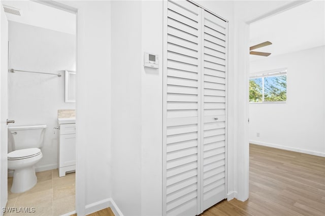 bathroom featuring wood-type flooring, ceiling fan, vanity, and toilet