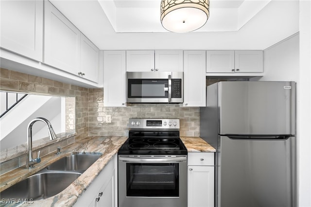 kitchen with sink, appliances with stainless steel finishes, and white cabinetry