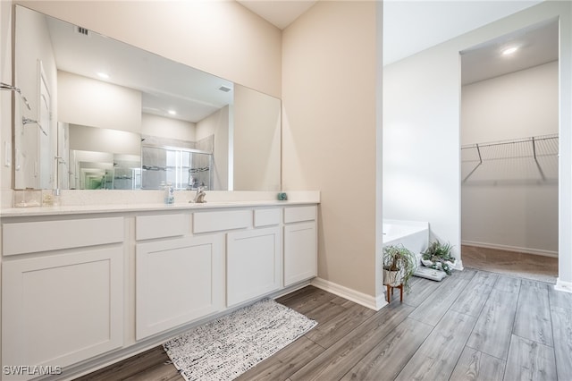 bathroom featuring hardwood / wood-style flooring, vanity, and walk in shower