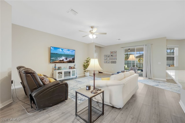 living room featuring light hardwood / wood-style flooring and ceiling fan