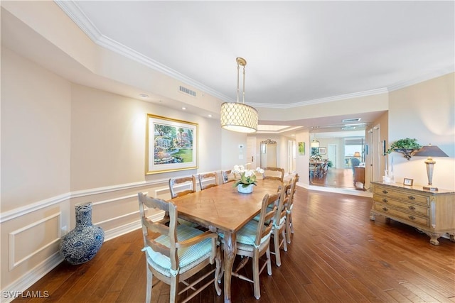 dining space featuring ornamental molding and dark hardwood / wood-style floors