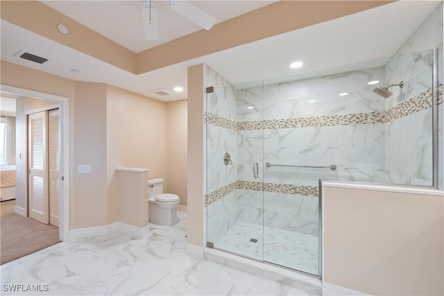 bathroom featuring ceiling fan, a shower with shower door, and toilet