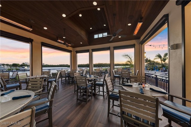 deck at dusk with ceiling fan and a water view